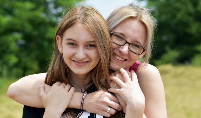 Zdjęcie przedstawia uśmiechnięte dwie kobiety - matkę i córkę.