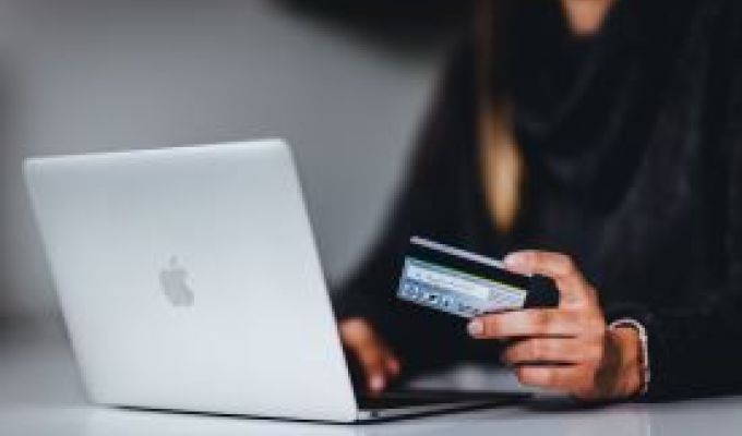 MacBook i karta płatnicza w ręce