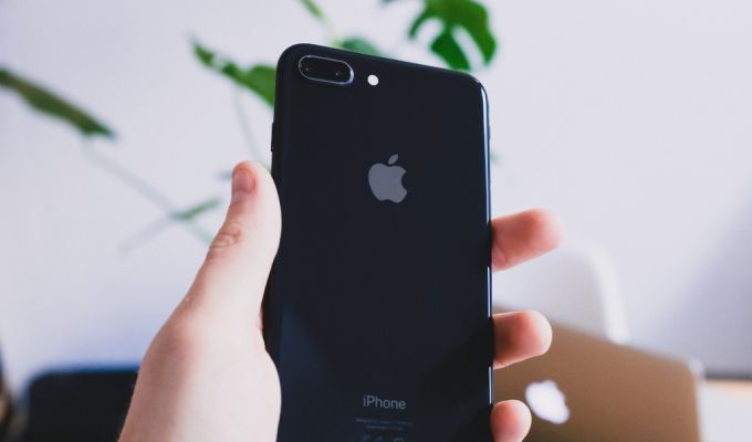 Zdjęcie przedstawia IPhone, który jest trzymany w ręce
